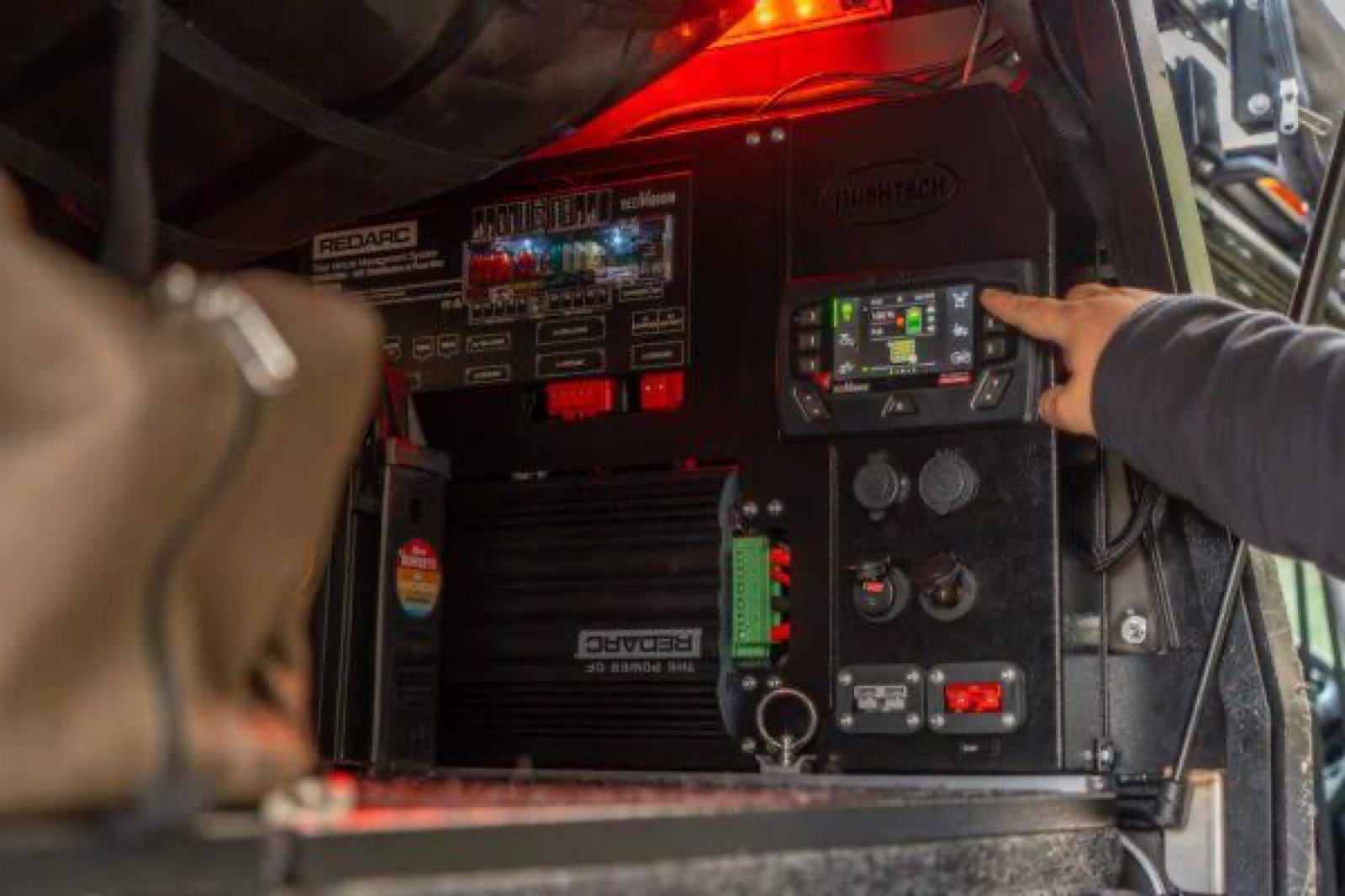 REDARC RedVision control panel installed in a vehicle drawer — dramatic red lighting