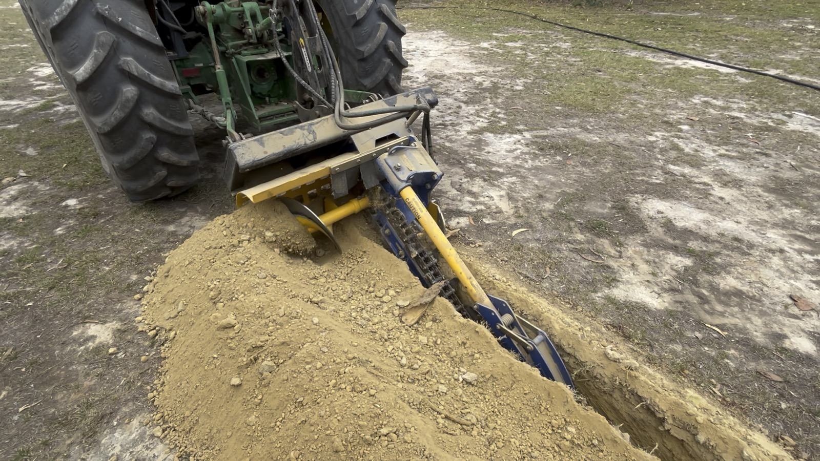 Tractor laying cable trench at a remote property